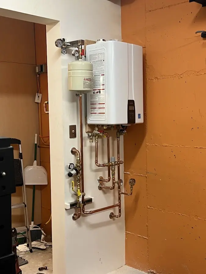 Plumbing technician inspecting water heater connections in Northwood